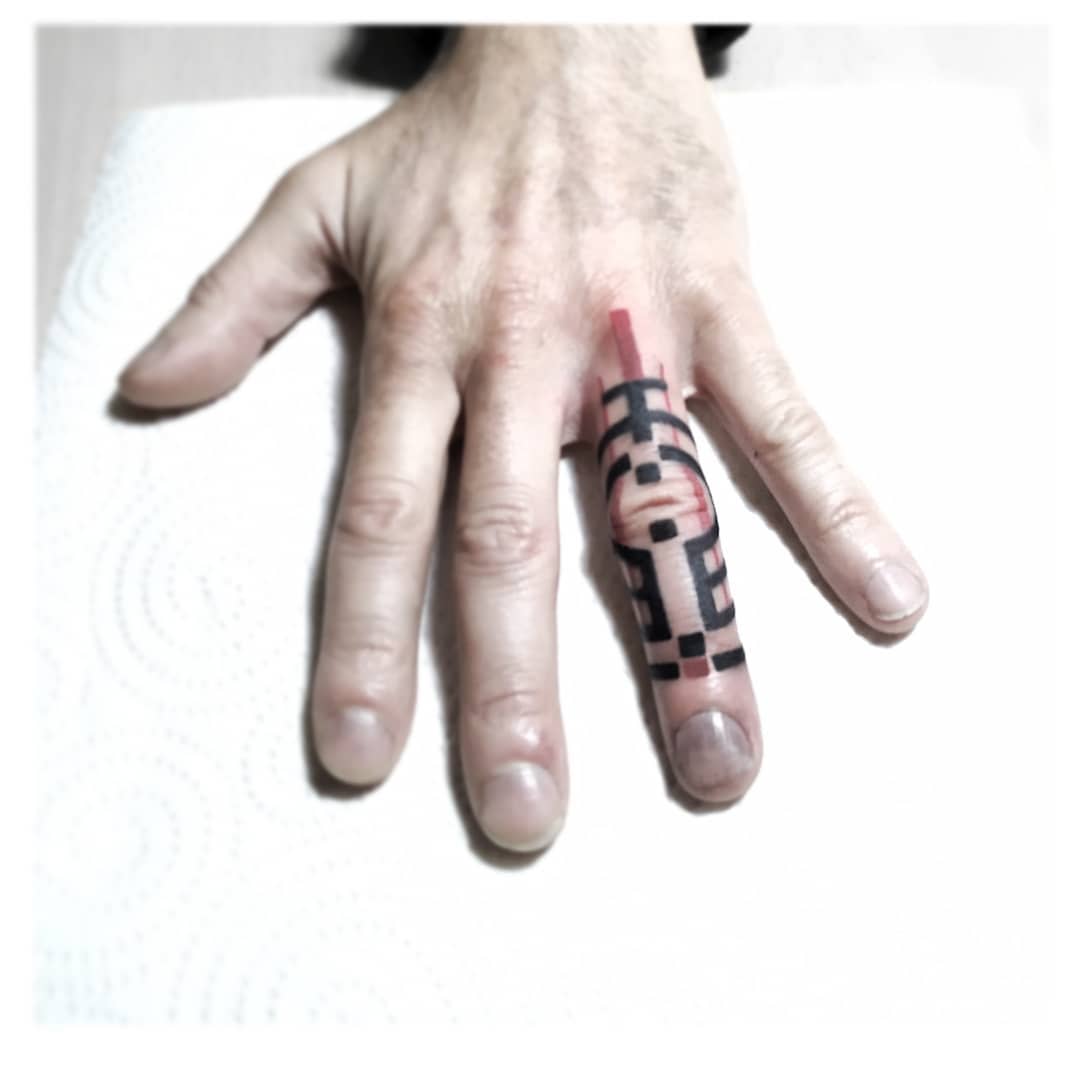 Minimalist cyberpunk tattoo on finger featuring a geometric design in black and red ink